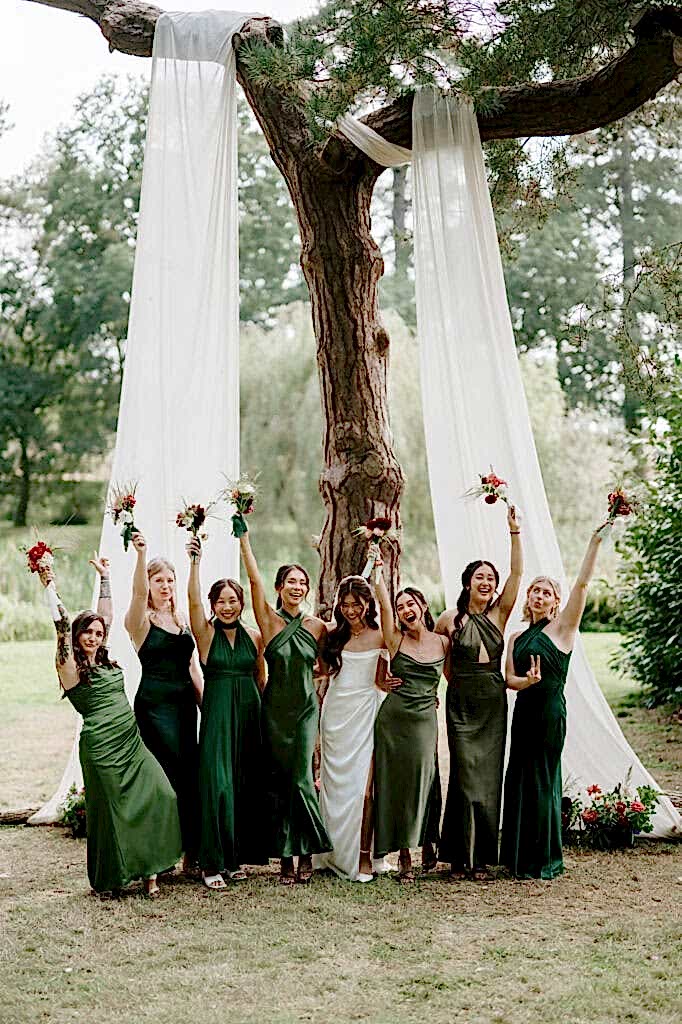 Bridesmaids in green dresses with the bride celebrating.