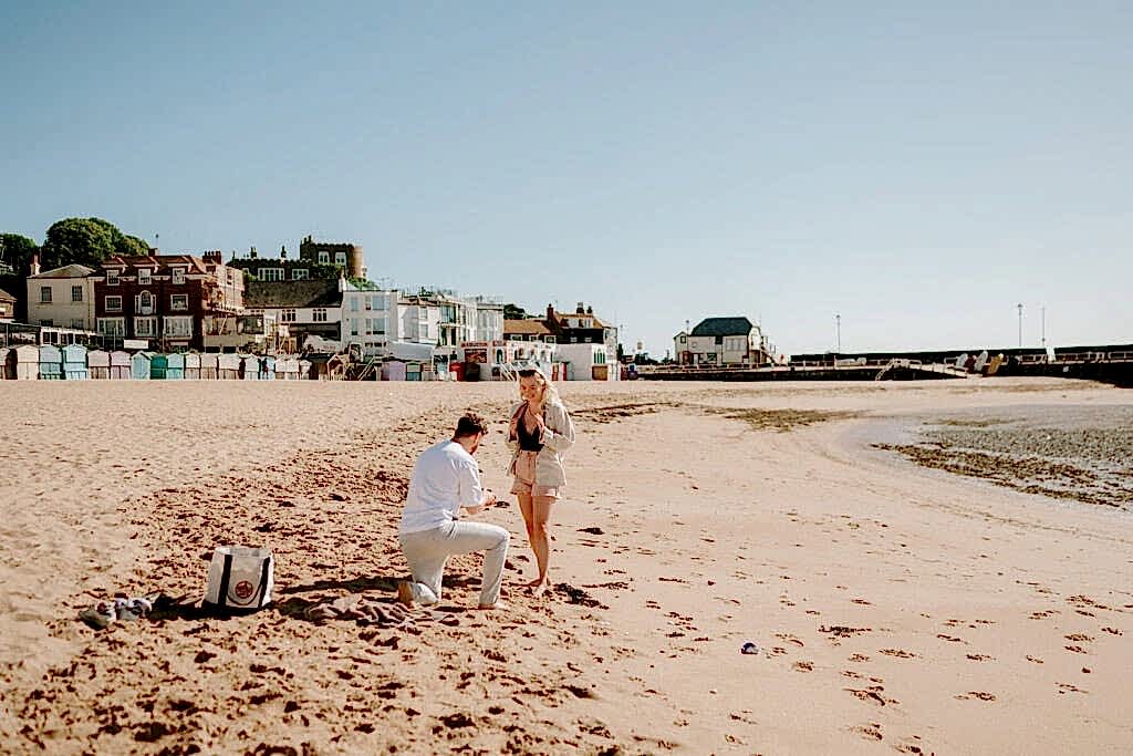 Proposal on viking bay broadstairs with buildings in background taken by broadstairs wedding photographer