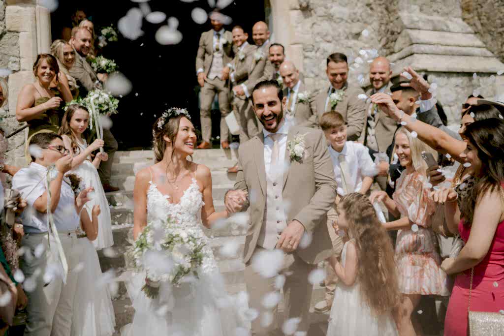 Newlyweds exit church with confetti celebration.