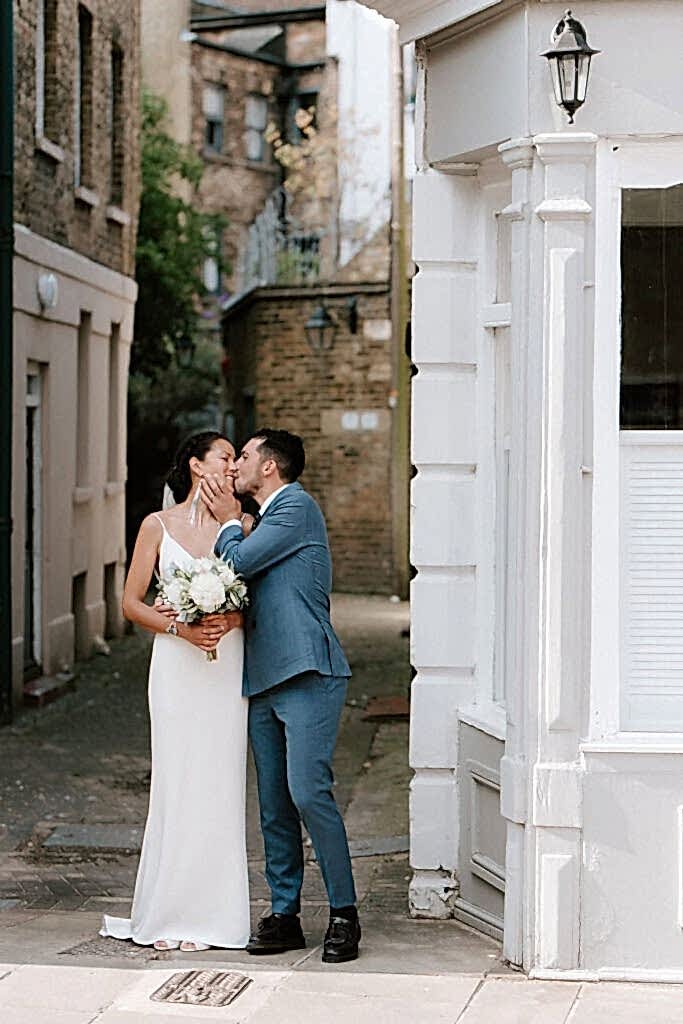 Bride and groom kissing in London street.