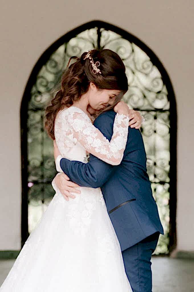 Bride and groom embrace at wedding ceremony.
